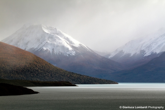 Nei pressi del Glaciar Perito Moreno, nella Provincia di Santa Cruz, Patagonia Argentina, timidi raggi del Sole attraversano la spessa coltre di nuvole sul Lago Argentino durante una forte nevicata, andando ad illuminare le pareti delle montagne della Cordigliera delle Ande e lo specchio d'acqua del lago. La luce sublime di questa scena è tutt'altro che rara nelle lande patagoniche.