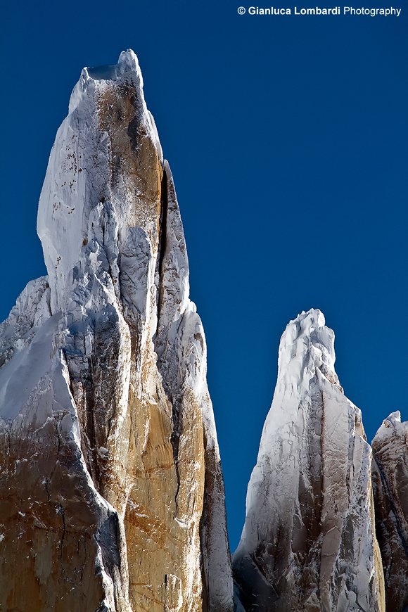 Dettaglio della cima del Cerro Torre coi suoi funghi di ghiaccio, accompagnata dalla cima minore di Aguja (guglia) Egger, di 2850 m.s.l.m., nel Parque Nacional Los Glaciares (Santa Cruz, Patagonia Argentina). Sublimati dall'aria gelida di Campo de Hielo Sur, i funghi di ghiaccio formatisi sulla sommità della montagna, cadono a valle da un momento all'altro. La vetta del Cerro Torre è considerata fra le più inaccessibili del Mondo perché, qualunque via si scelga, bisogna affrontare almeno 900 metri di parete granitica, per arrivare ad una cima perennemente ricoperta dai funghi di ghiaccio in continua genesi.