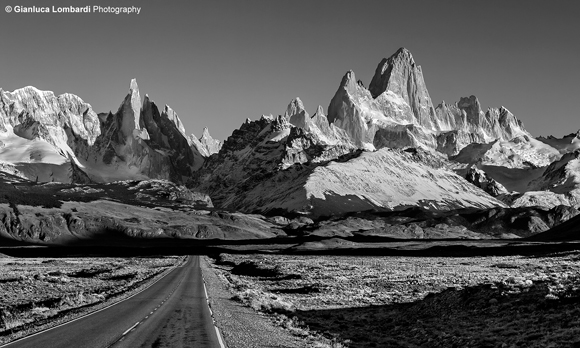 Ruta Provincial 23 in direzione El Chaltén (Santa Cruz, Patagonia Argentina). Cerro El Chaltén (o Fitz Roy, 3358 m.s.l.m.) e Aguja Poincenot (3002 m.s.l.m.) sulla destra, Cerro Torre (3128 m.s.l.m.) sulla sinistra.